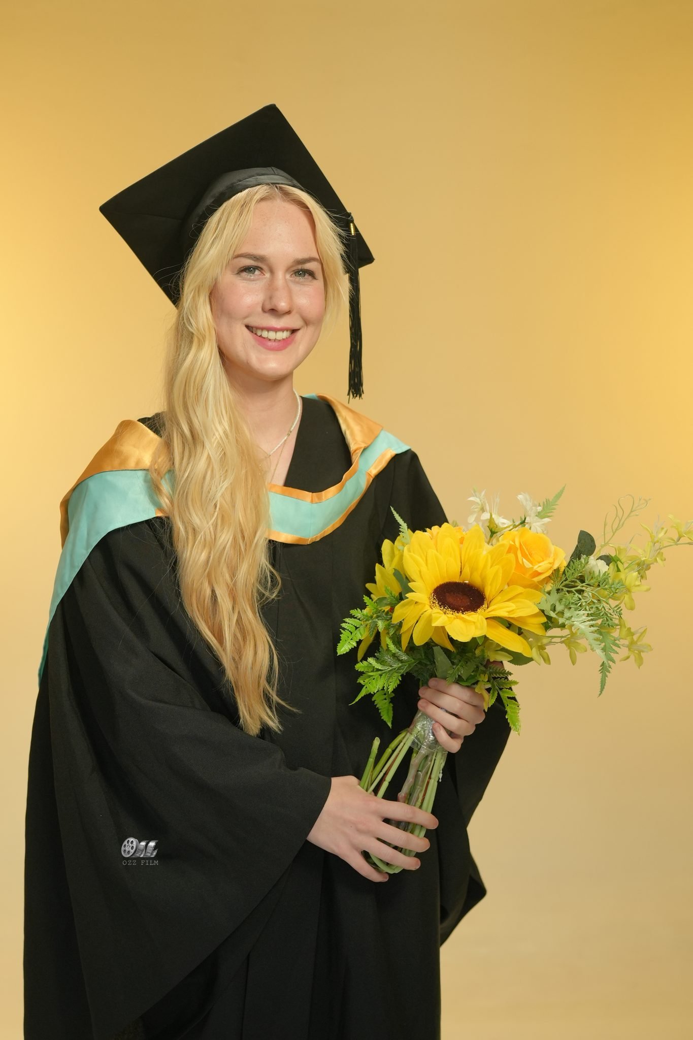 Monash University Bachelor of Education graduation gown with bouquet